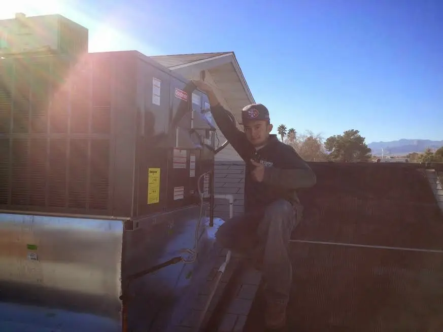 HVAC technician performing Heat Pump Repair on a rooftop unit in Carolina Beach